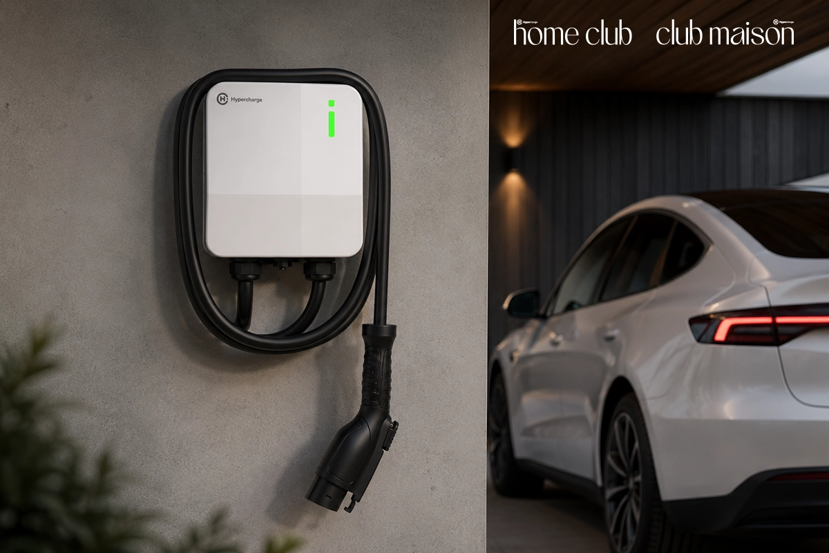 A white Hypercharge Home electric vehicle charger is mounted on a wall with its cable neatly coiled. A white electric car is parked nearby. Text in the top right reads “home club club maison” and highlights 8 Reasons to Join Hypercharge Home Club. A white Hypercharge Home electric vehicle charger is mounted on a wall with its cable neatly coiled. A white electric car is parked nearby. Text in the top right reads “home club club maison” and highlights 8 Reasons to Join Hypercharge Home Club.